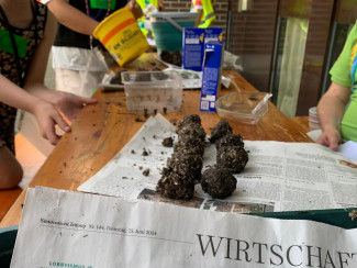 Spielstadt: Kinder stellen in der Gärtnerei Saatkugeln her